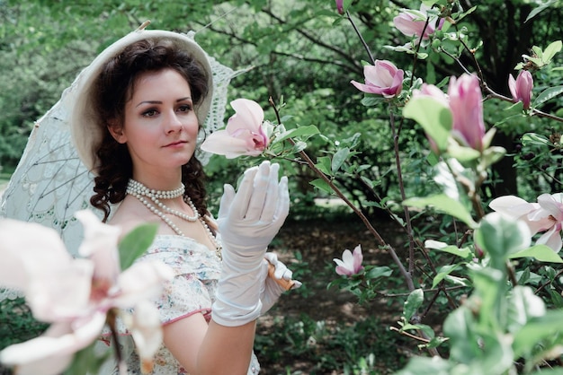 Sposa in un cappello vicino a un fiore rosa