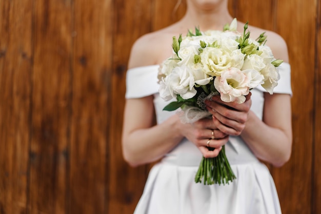 Sposa irriconoscibile in abito bianco con bouquet da vicino