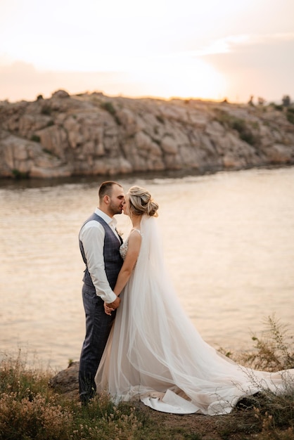 Sposa ragazza bionda e sposo vicino al fiume