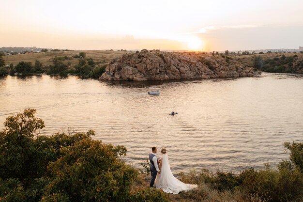 Sposa ragazza bionda e sposo vicino al fiume