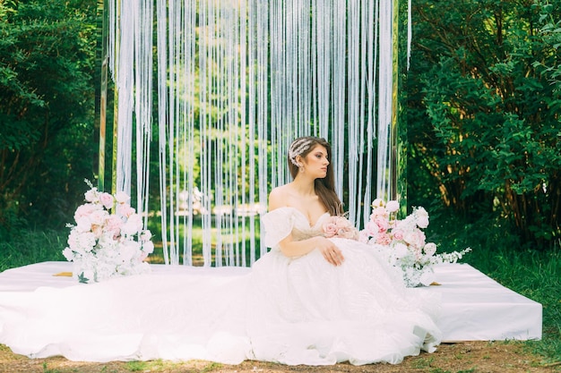 Sposa vicino ad arco di nozze con fiori