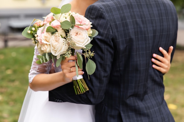 Sposi al giorno delle nozze, sposi con bouquet di fiori da sposa