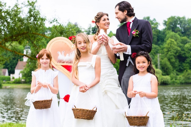 Sposi e figli dei fiori con le colombe