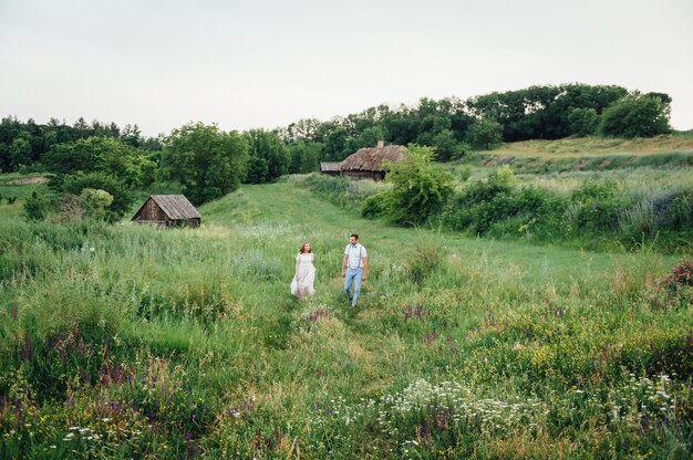 Sposi felici che camminano sull'erba verde