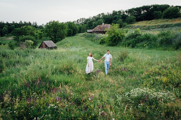 Sposi felici che camminano sull'erba verde