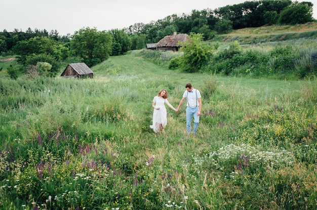 Sposi felici che camminano sull'erba verde