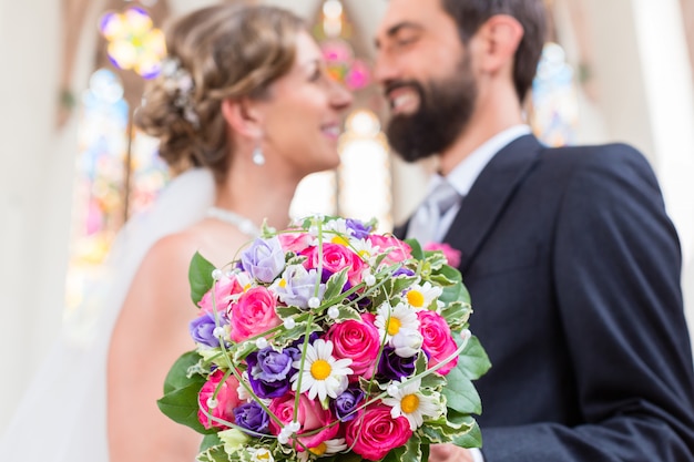 Sposi in chiesa con bouquet di fiori