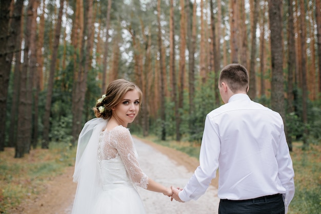 Sposi nella foresta Bella sposa e sposo a passeggio.