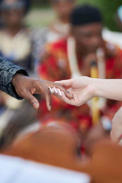 Sposo afroamericano e sposa caucasica La sposa mette un anello sul matrimonio del dito dello sposo