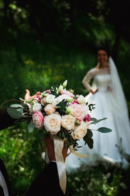 Sposo amorevole con un mazzo di fiori da sposa per una passeggiata con la sposa 2