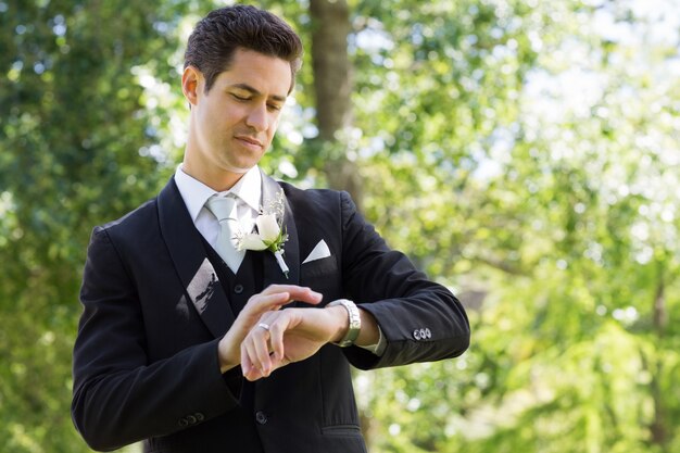 Sposo astuto che controlla tempo in giardino