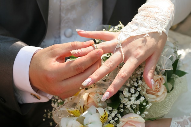 Sposo che mette fede nuziale sul dito della sposa