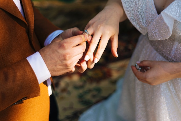 Sposo che mette l'anello nuziale sul dito della sposa, cerimonia di matrimonio