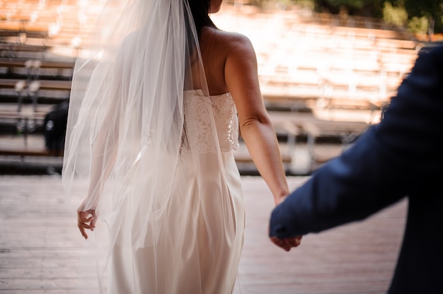 Sposo che segue la sua bella sposa vestita con un abito bianco