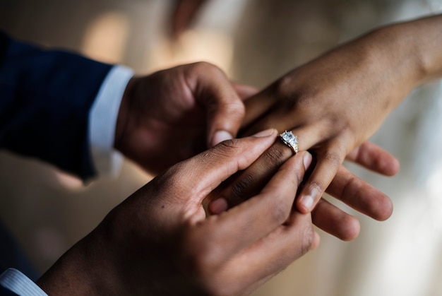 Sposo indossare la mano della sposa della fede nuziale