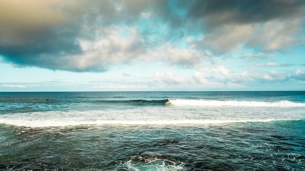 spot per fare surf sull'oceano di fronte alla spiaggia. vacanza e attività di surf sportivo con molte persone che nuotano sulle onde. divertiti e goditi la natura con le tavole da surf