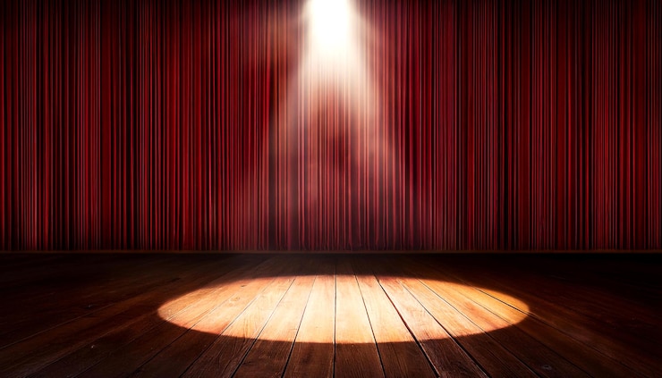 Foto spotlight drammatico sul palco con tende rosse