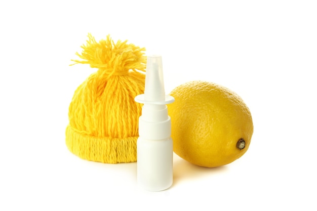 Spray nasale, limone e berretto lavorato a maglia isolato su sfondo bianco
