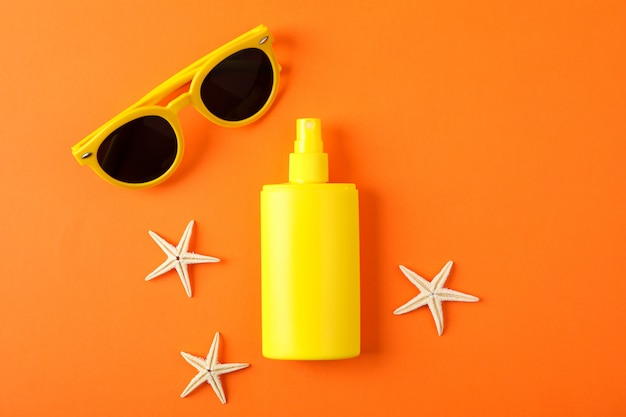 spray solare, stelle marine e occhiali da sole