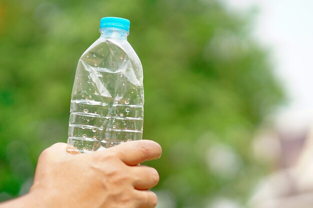 Spremere a mano la bottiglia d'acqua vuota preparare gettare nella spazzatura.