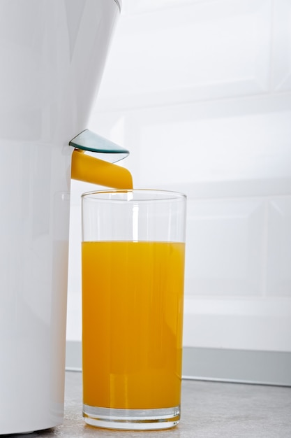 Spremiagrumi con un bicchiere di succo d'arancia fresco in una cucina moderna.