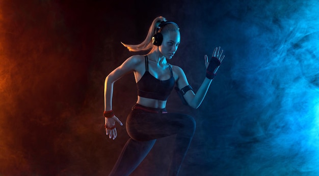 Sprinter correre donna atletica forte correre su sfondo nero indossare in abbigliamento sportivo fitness e