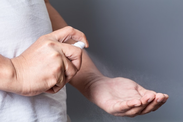 Spruzzare alcol disinfettando la mano