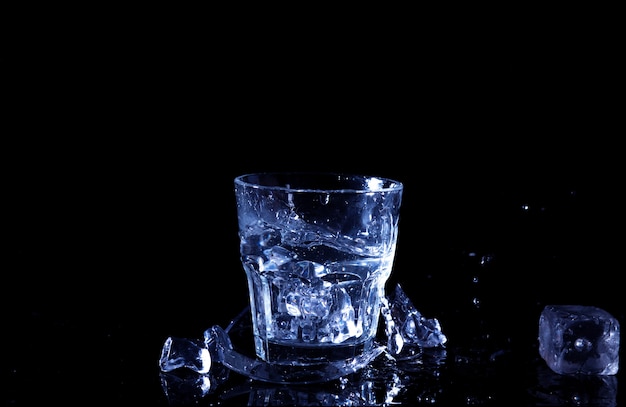 Spruzzata dell'acqua in un bicchiere. Un bicchiere di acqua fredda. Acqua fredda con ghiaccio