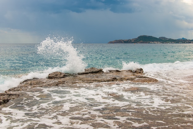 Spruzzata dell'onda sulle pietre sulla costa