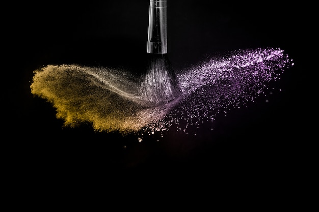 Spruzzata di polvere d&#39;oro e viola a sfondo nero