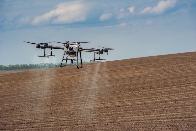 Spruzzatore drone sullo sfondo di un campo arato agricoltura di precisione l'ultima agricoltura