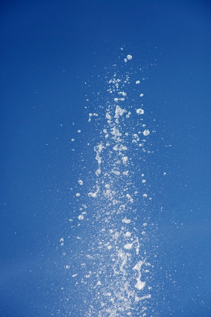 Spruzzi d'acqua dalla fontana sullo sfondo del cielo blu