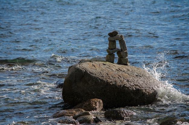 Spruzzi d&#39;acqua su un Inuksuk nella baia inglese di Stanley Park, Vancouver, BC, Canada