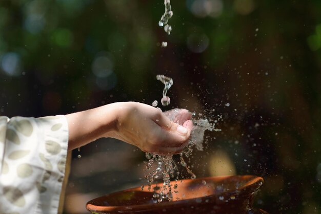 spruzzi di gocce d'acqua fresca sulla cura della pelle morbida della ragazza per le mani della donna sensuale