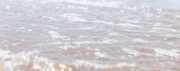 Spuma di mare con bolle sulla spiaggia di sabbia Viaggi di svago e turismo Closeup Spazio per testo Focus selettivo Formato panoramico