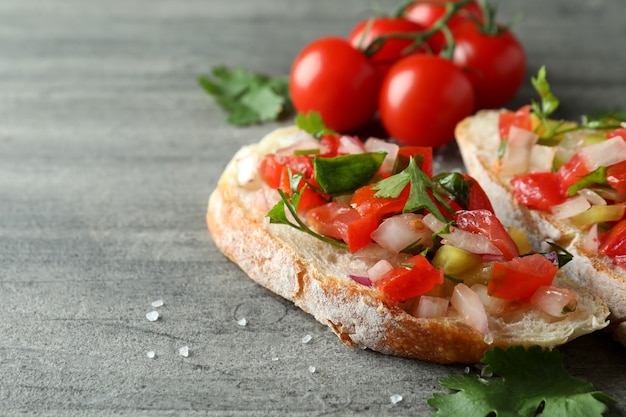 Spuntini deliziosi della bruschetta su fondo strutturato grigio