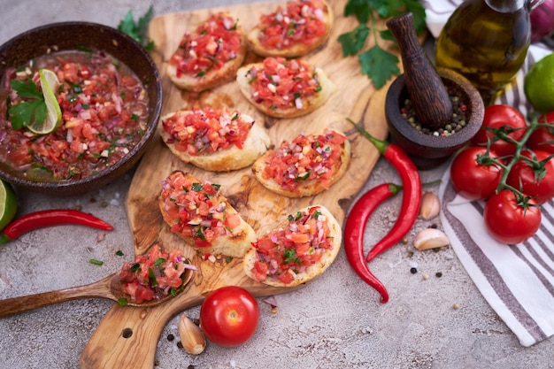 Spuntini gustosi della bruschetta della salsa alla cucina domestica sul tagliere di legno