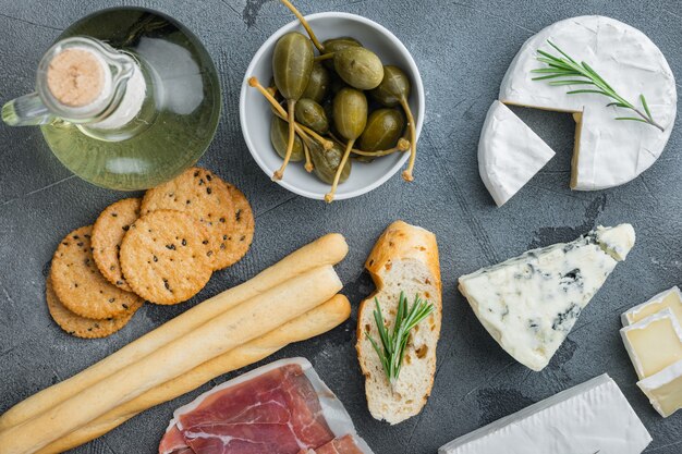 Spuntini italiani, formaggio a base di carne, set di erbe, sul tavolo grigio, piatto laici