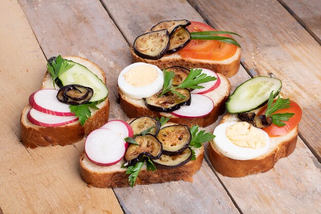 Spuntini sani con hummus, spinaci e pomodori sulla tavola di legno leggera, fine su