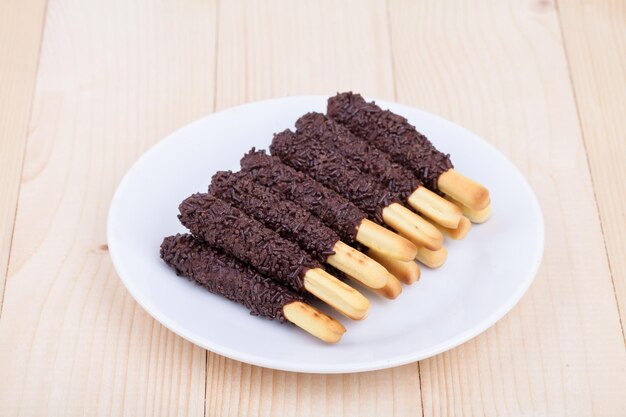 Spuntino biscotto stick ricoperto di cioccolato su legno blackground