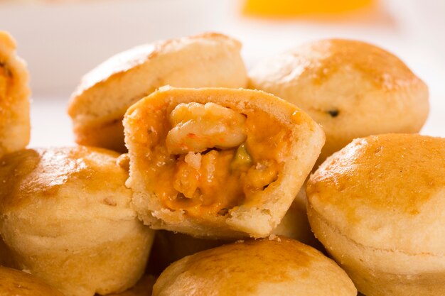 Spuntino brasiliano Empada. torta con gamberetti sul piatto bianco su fondo in legno