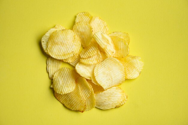 Spuntino con patatine fritte su sfondo giallo Vista dall'alto di patate croccanti