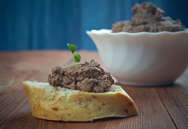 Spuntino di carne fatto in casa patè di fegato di pollo con pane su tavola di legno