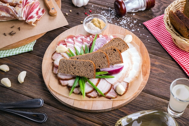 Spuntino di vodka. Lardo di maiale e pancetta su una tavola di legno.