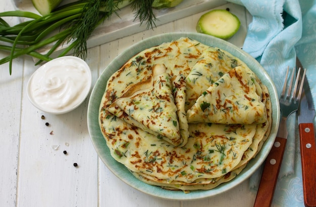 Spuntino o pranzo estivo Frittelle di zucchine con verdure servite con panna acida Copia spazio