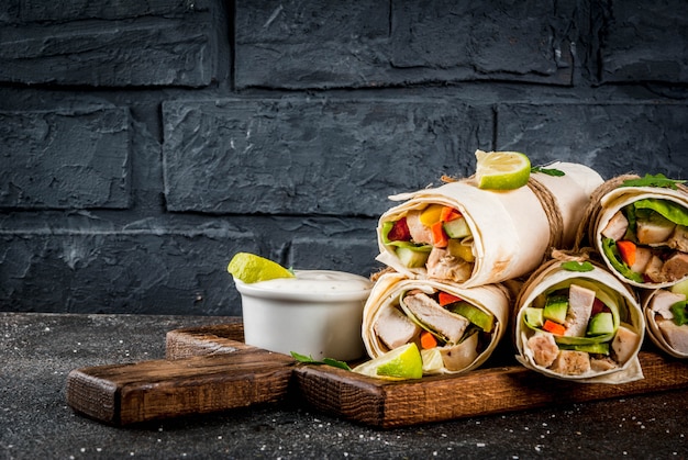 Spuntino salutare. Pila di involucri messicani di tortilla fajita cibo di strada con filetto di pollo alla griglia bufalo e verdure fresche