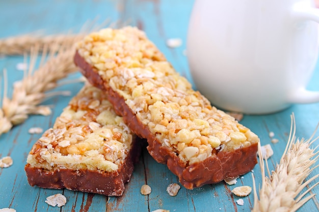 Spuntino sano, barre di muesli con uvetta e noci su sfondo blu