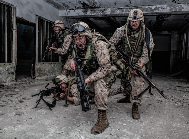 Squadra d'assalto dei marines americani, distaccamento speciale commando, squadra d'élite dell'esercito armata di arma automatica, urla e attacca il nemico, sfondando con la lotta, si precipita con il fuoco durante lo scontro a fuoco urbano