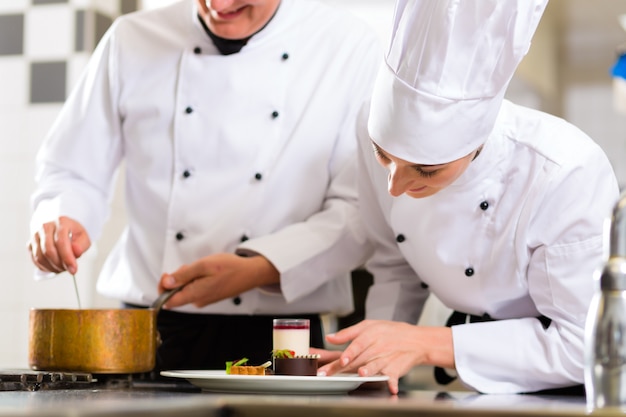 Squadra del cuoco unico nella cucina del ristorante con il dessert