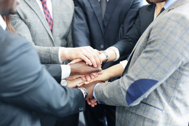 Squadra dell'uomo d'affari in vestito che tocca le mani insieme. Messa a fuoco selettiva